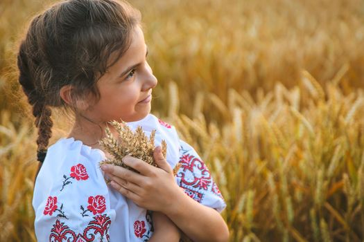 Child in a wheat field. In vyshyvanka, the concept of the Independence Day of Ukraine. Selective focus. Kid.