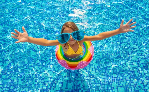 The child is swimming in the pool. Selective focus. Kid.