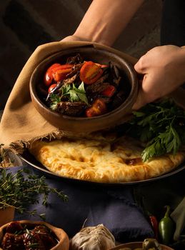 A vertical shot of a chef serving a gourmet salad dish