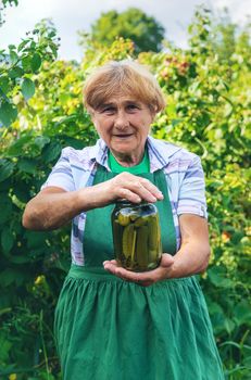 Grandmother canning cucumbers for the winter. Selective focus. Food.