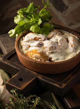 A vertical shot of a chicken covered in a creamy sauce