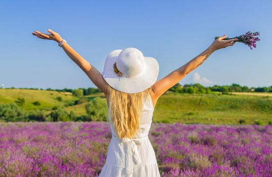 Woman with hat in lavender field. Selective focus. Nature.