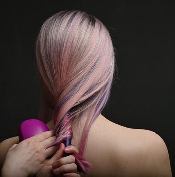 Dyed hair model back view in hairdresser's hand
