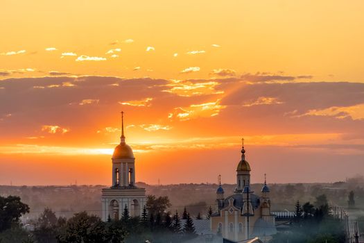 Golden domes with Orthodox crosses on the church.Temple or cathedral on the background of an evening sunset with a golden sky. A lonely church at dusk with sunset clouds.Golden Hour,skyline,horizon