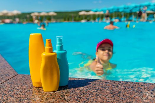 Sunscreen by the children pool. Selective focus. Kid.