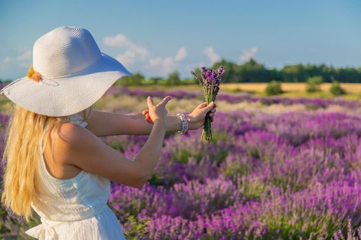 Woman with hat in lavender field. Selective focus. Nature.
