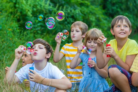 Children blow bubbles in the street. Selective focus. nature.