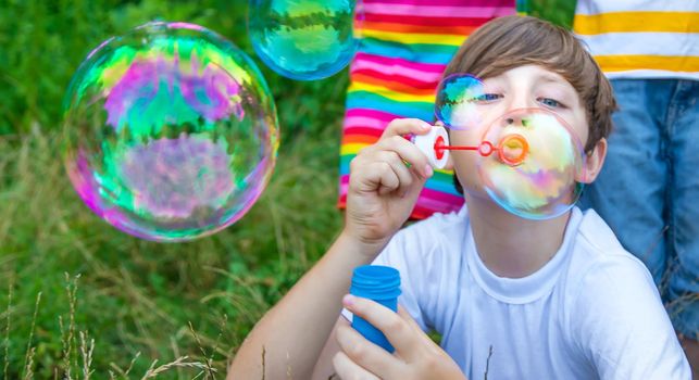 Children blow bubbles in the street. Selective focus. nature.