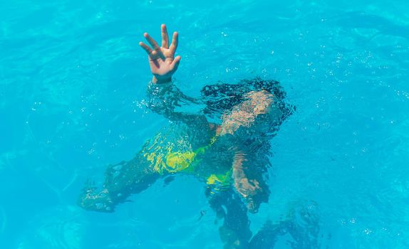 The child is drowning in water. Selective focus. Kid.