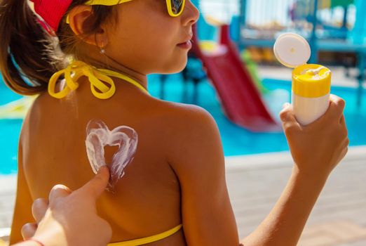 Sunscreen on the back of the child. Selective focus. Kid.