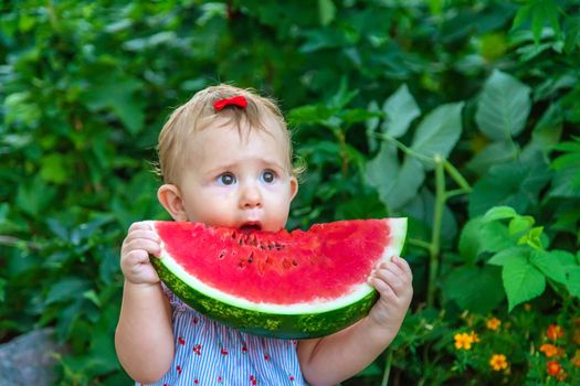 Baby eats watermelon in summer. Selective focus. Food.