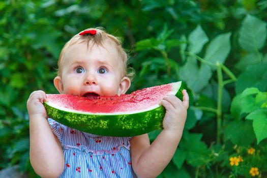 Baby eats watermelon in summer. Selective focus. Food.