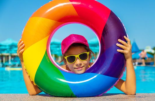 The child swims in the pool in a circle. Selective focus. Kid.
