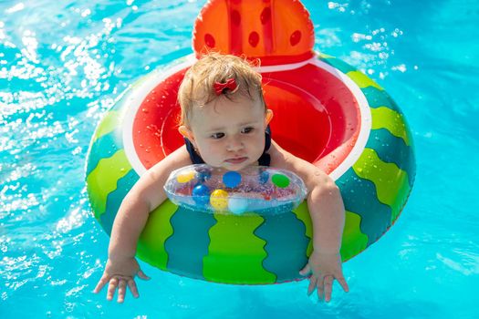 Baby swims in a circle in the pool. Selective focus. Nature.