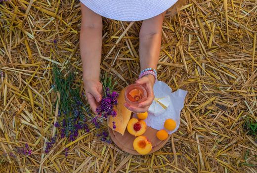 A woman holds wine in glasses. Picnic in the lavender field. Selective focus. nature.