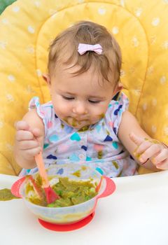 Baby is eating vegetable puree. Selective focus. Child.