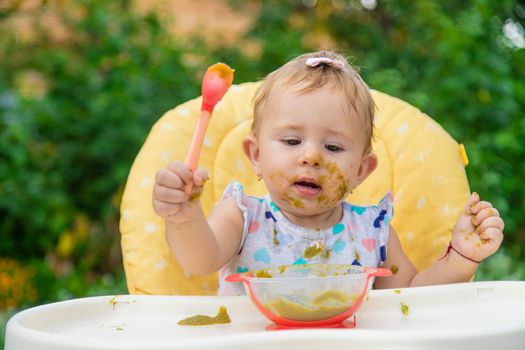Baby is eating vegetable puree. Selective focus. Child.