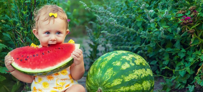 The child eats watermelon in the summer. Selective focus. Baby.