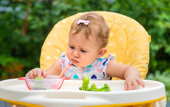Baby eats pieces of broccoli vegetables. Selective focus. Child.