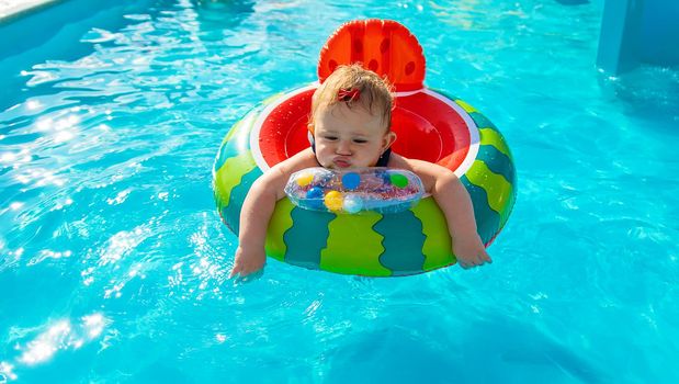 Baby swims in a circle in the pool. Selective focus. Nature.