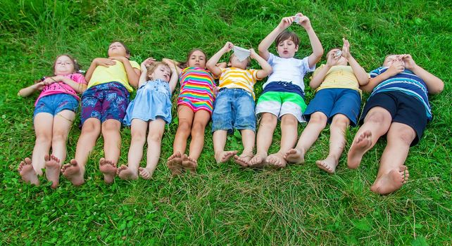 Children's feet lie on the grass. Selective focus. Kid.