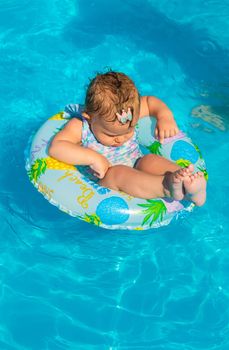 Baby in the pool swims in a circle. Selective focus. Child.