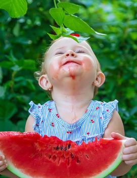 Baby eats watermelon in summer. Selective focus. Food.