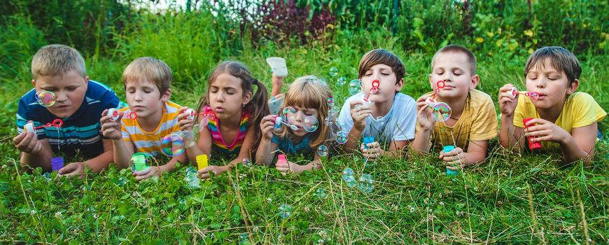 Children blow bubbles in the street. Selective focus. nature.