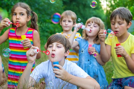 Children blow bubbles in the street. Selective focus. nature.