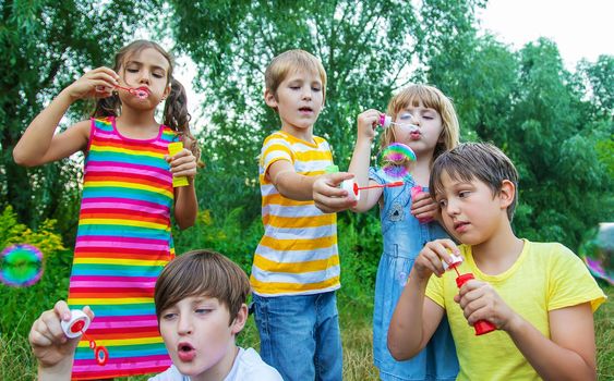 Children blow bubbles in the street. Selective focus. nature.