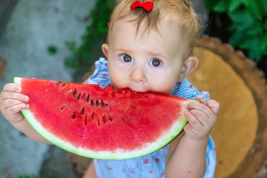 Baby eats watermelon in summer. Selective focus. Food.