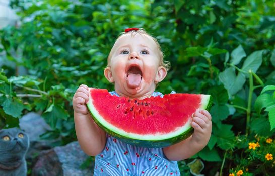 Baby eats watermelon in summer. Selective focus. Food.