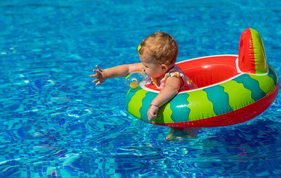 Baby swims in a circle in the pool. Selective focus. Child.