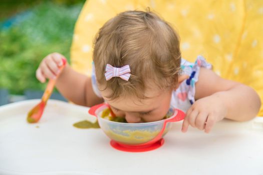 Baby is eating vegetable puree. Selective focus. Child.