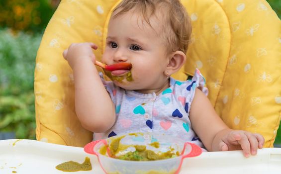 Baby is eating vegetable puree. Selective focus. Child.