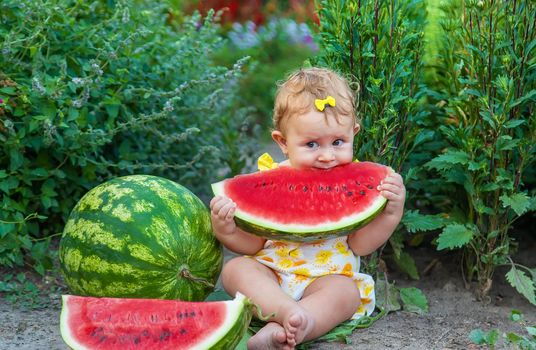 The child eats watermelon in the summer. Selective focus. Baby.