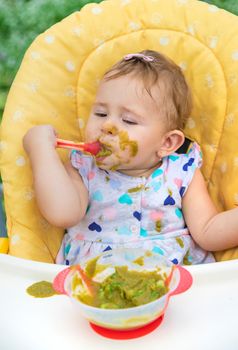 Baby is eating vegetable puree. Selective focus. Child.
