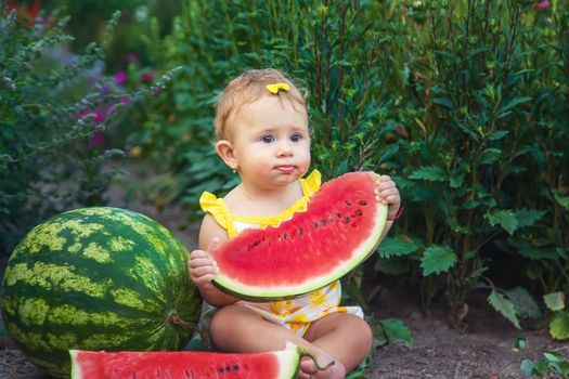 The child eats watermelon in the summer. Selective focus. Baby.