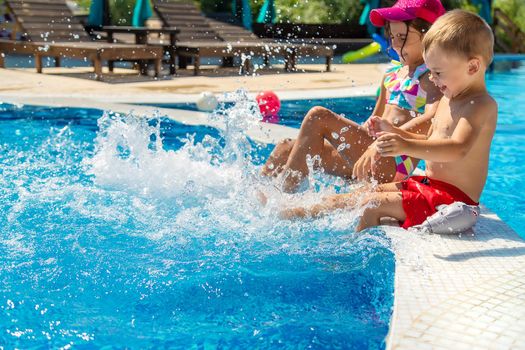 Children splash their feet in the pool. Selective focus. Kids.