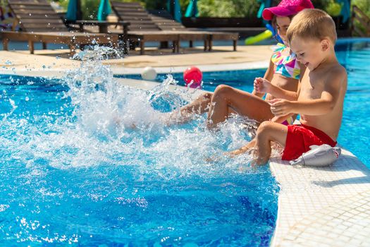 Children splash their feet in the pool. Selective focus. Kids.