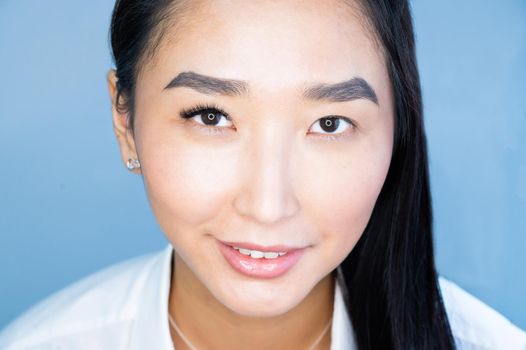 Portrait of a beautiful asian woman during eyelash extension procedure. Double eyelash volume before and after