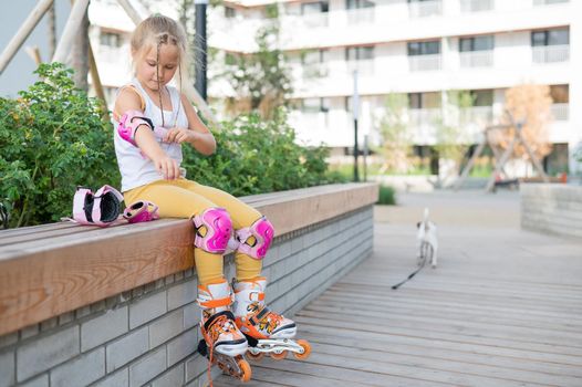 Little girl learns to roller skate outdoors