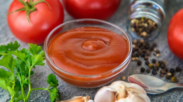 Ketchup in a bowl on the table. Selective focus. Food.