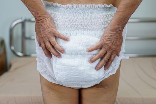 Asian elder senior woman patient wearing adult incontinence diaper pad in hospital.