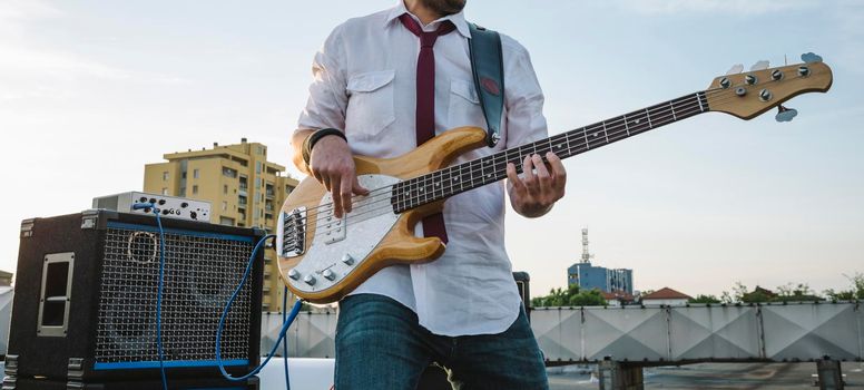 Bass player playing outdoors on stage.