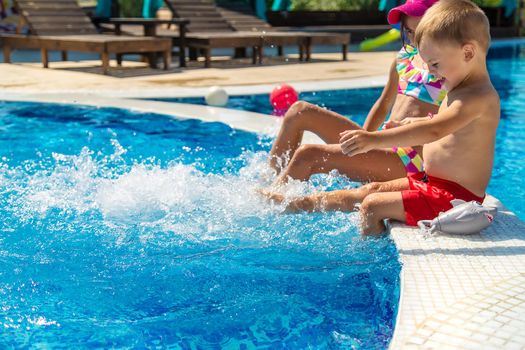 Children splash their feet in the pool. Selective focus. Kids.