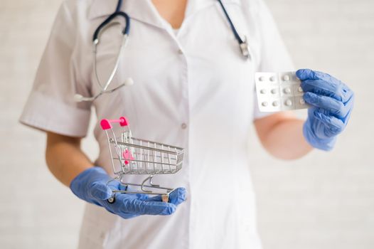 A faceless doctor puts a blister of pills in a mini shopping cart