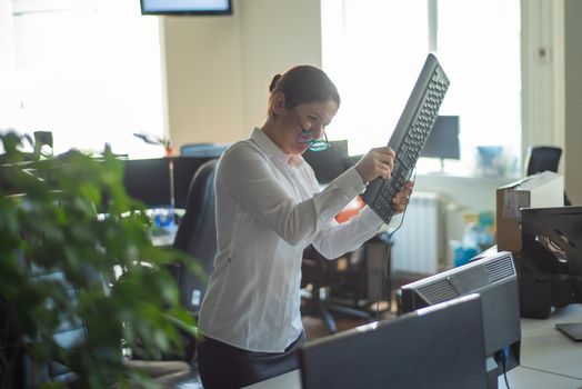 A woman freaks out and gets depressed from a mistake and breaks the keyboard on the monitor. Female manager gets angry and crashes a computer. Office clerk is stressed at work. Unstable psyche