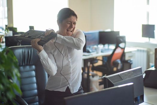 A woman freaks out and gets depressed from a mistake and breaks the keyboard on the monitor. Female manager gets angry and crashes a computer. Office clerk is stressed at work. Unstable psyche