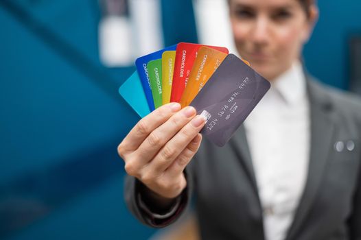 Business woman in a suit holds many different credit cards